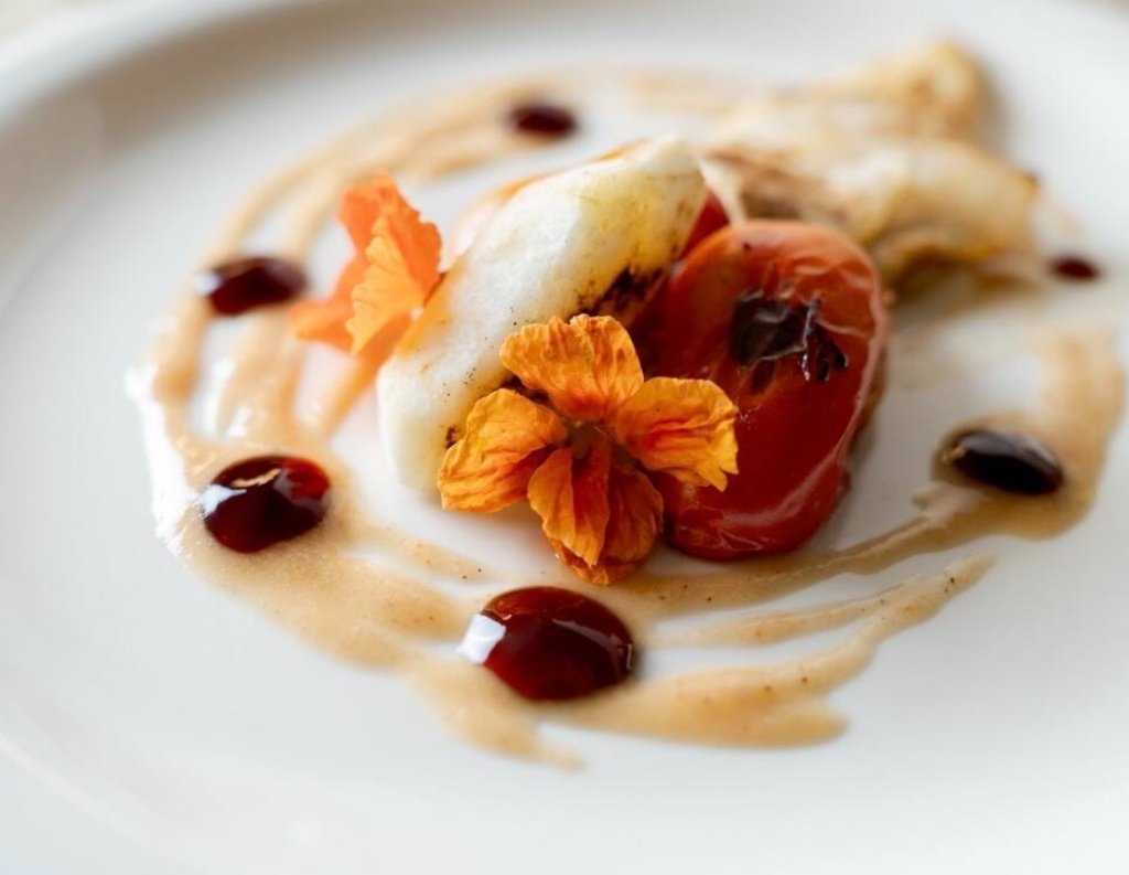 Seared white fish with edible flowers and balsamic reduction — a Communion at Chez Nickel plated dish