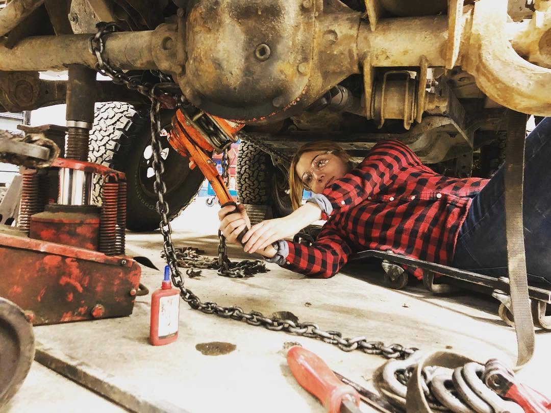 Working under the Jeep with a wrench and chains during the engine rebuild