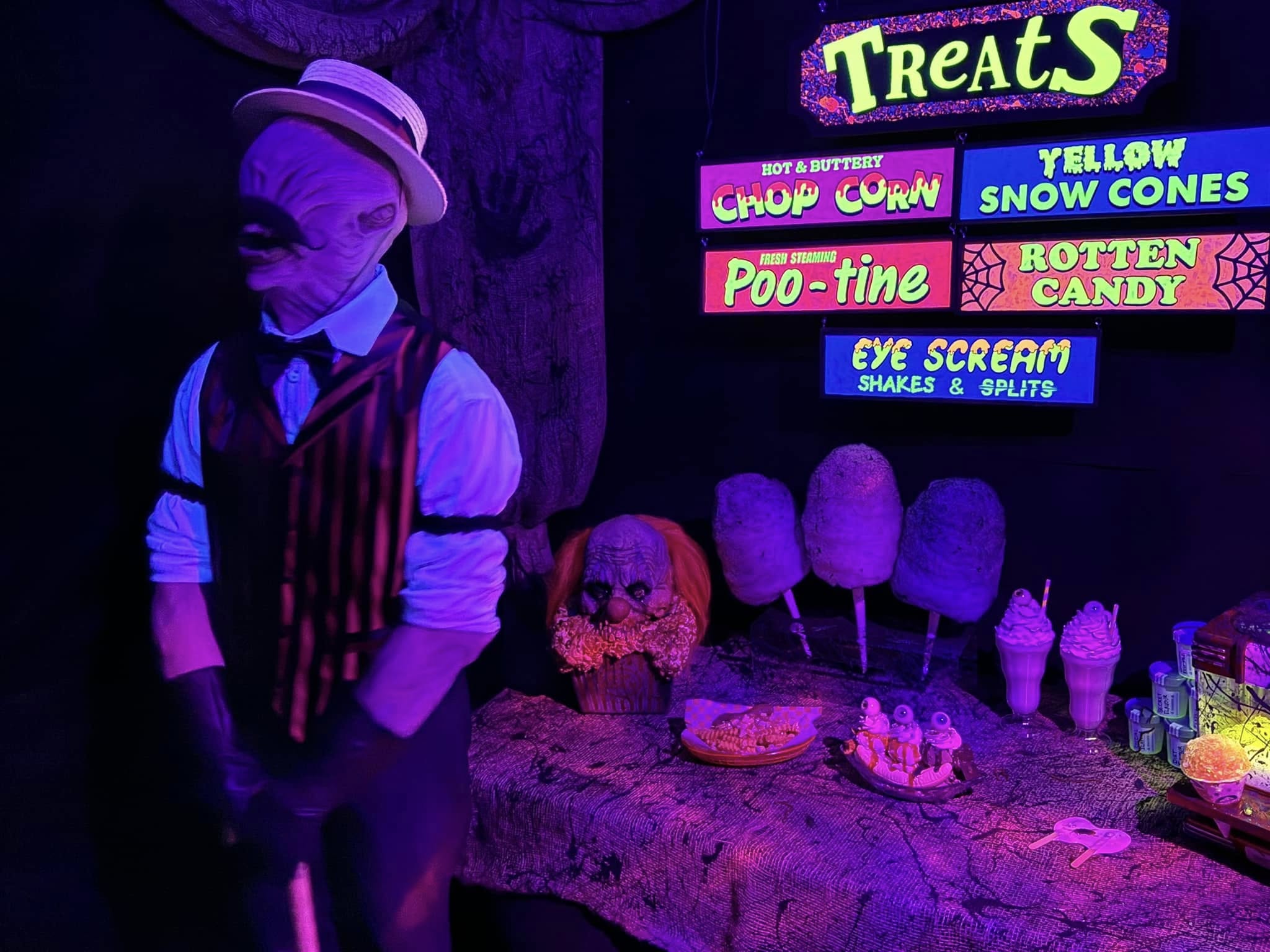Blacklight treats concession stand inside Nightmare on Norwood with neon menu signs