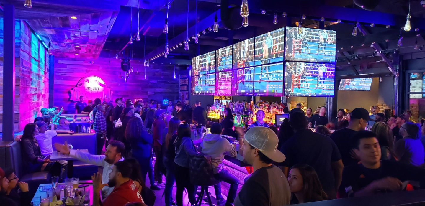 A packed bar at night under the video walls at Lookout Tavern