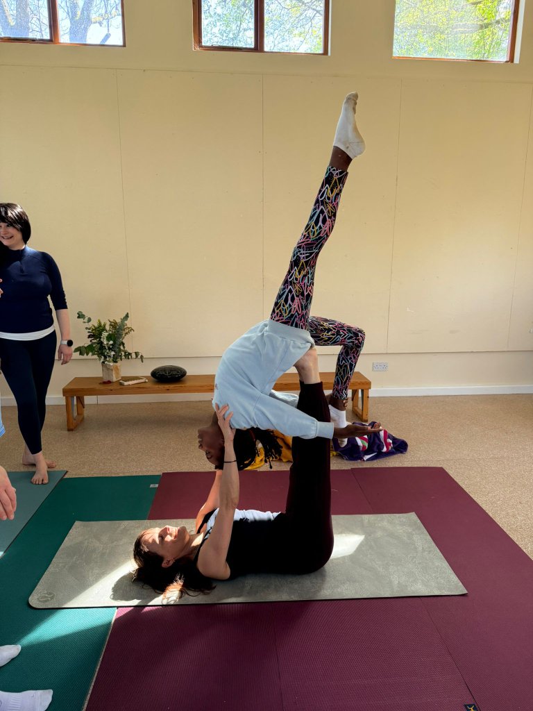 Acro-yoga bird pose in a bright studio