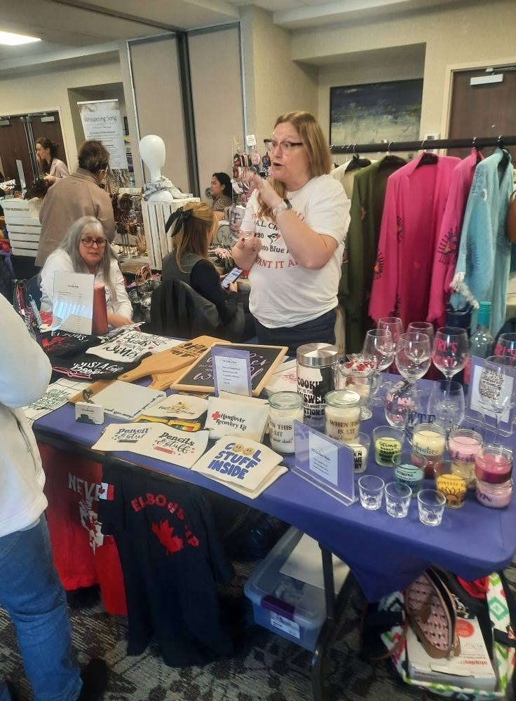 Tote bags, candles, and apparel vendor table