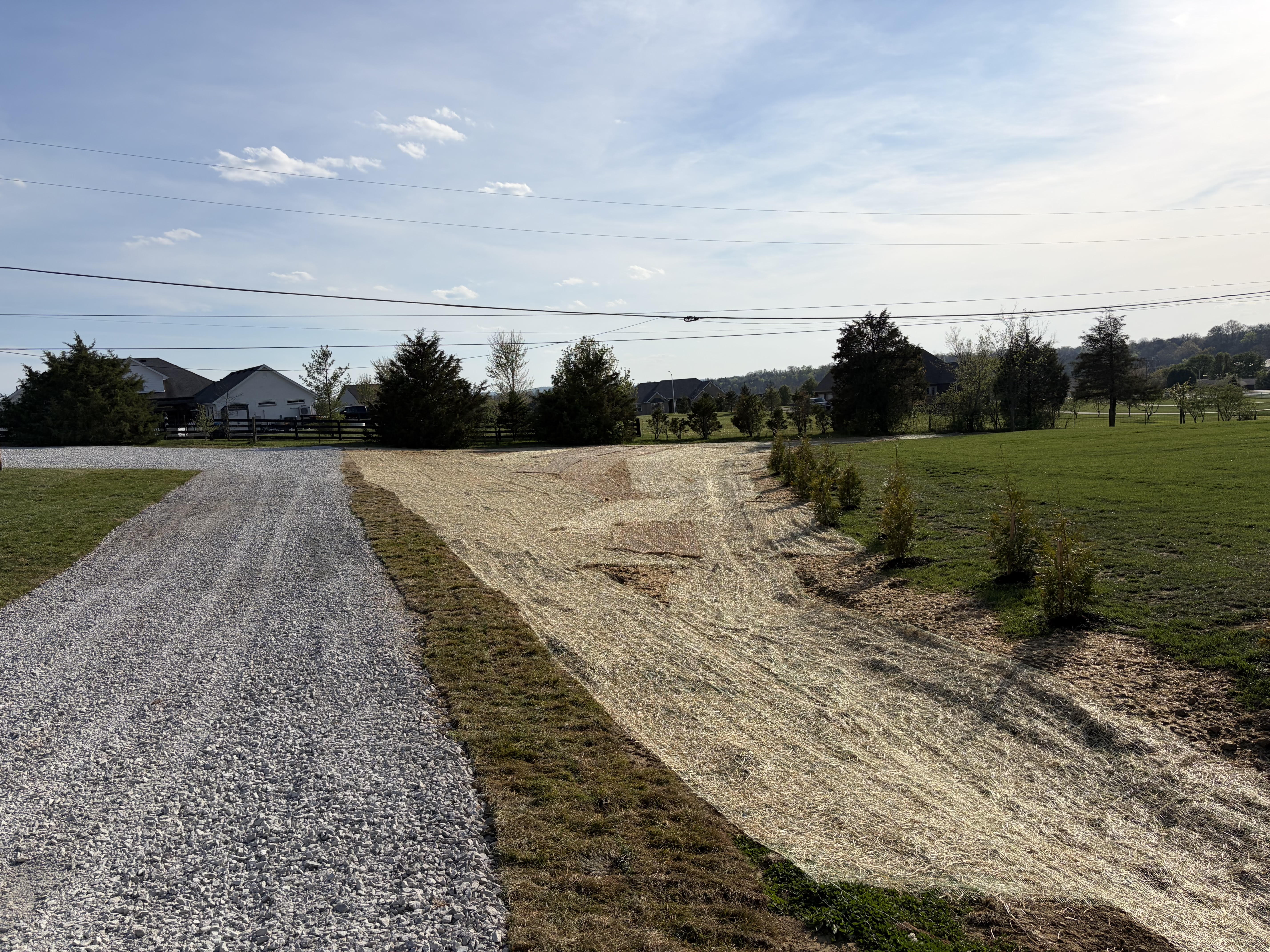 Finished gravel drive and straw matting over a graded drainage area