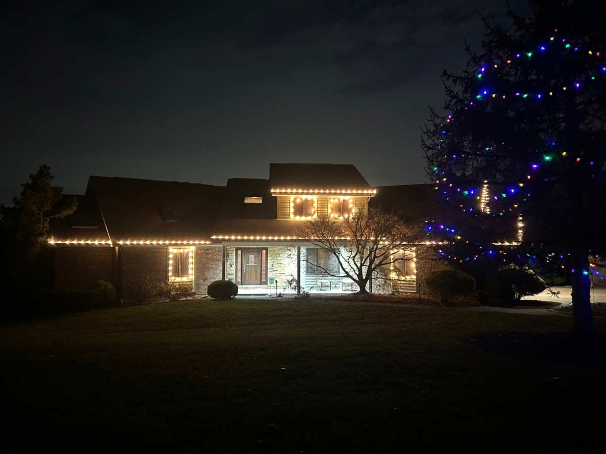 Warm white Christmas lights on a stone Cincinnati home at night