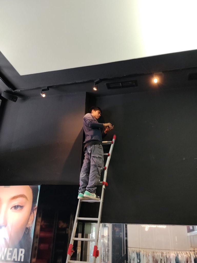 Técnico de Ibiza Solutions realizando mantenimiento de iluminación en la tienda MAC Cosmetics de Ibiza
