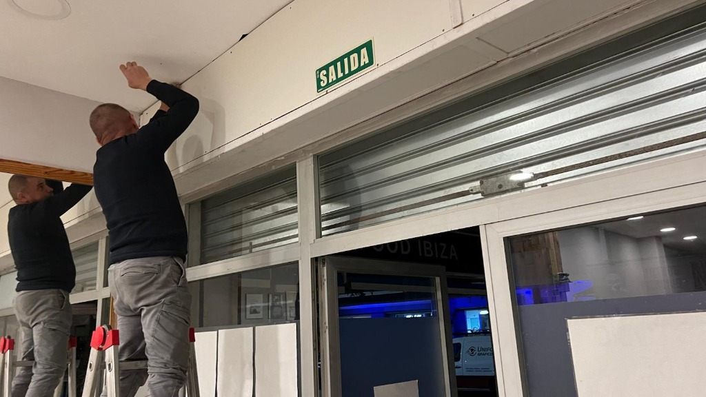 Técnicos de Ibiza Solutions reparando la persiana comercial del gimnasio