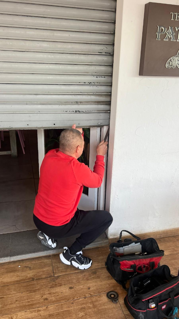 Técnico ajustando guías y mecanismo del cierre comercial dañado