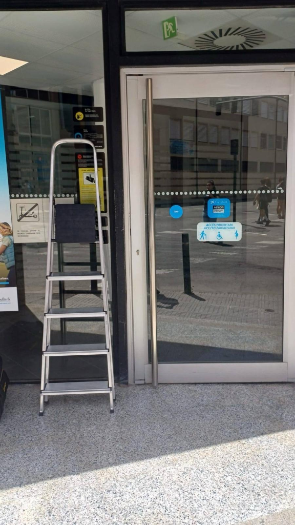 Trabajos de mantenimiento en la entrada de una oficina CaixaBank en Ibiza