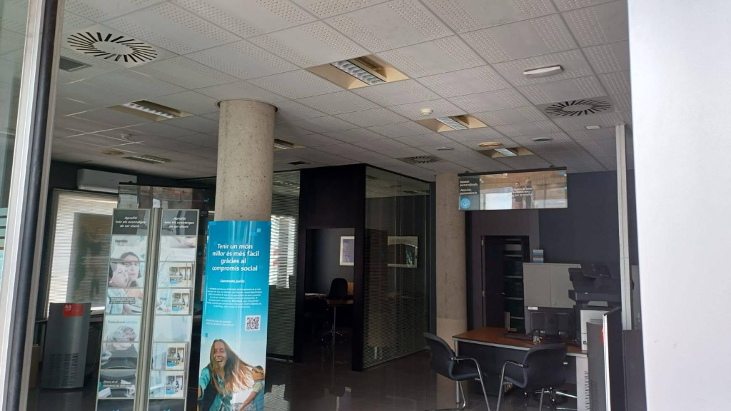 Interior de sucursal CaixaBank con sistema de climatización mantenido por Ibiza Solutions