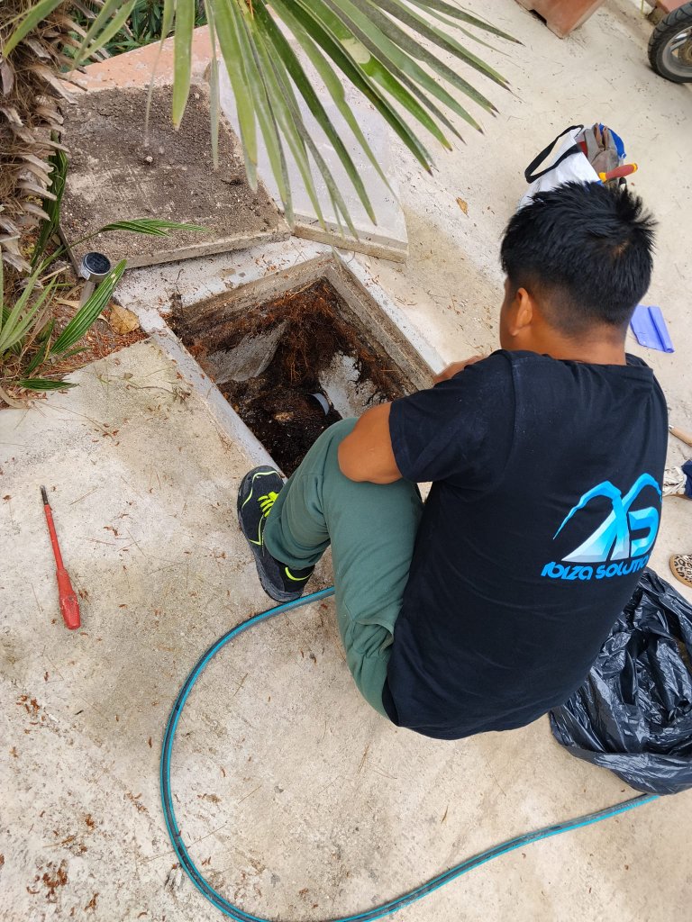 Técnico Ibiza Solutions trabajando en desatasco con raíces