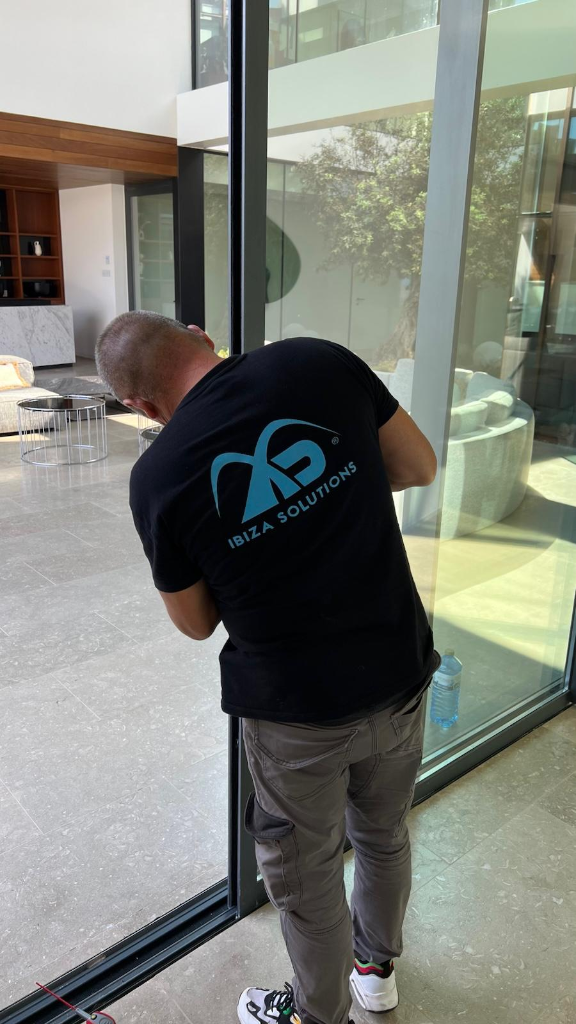 Técnico Ibiza Solutions revisando las carpinterías de vidrio en la villa