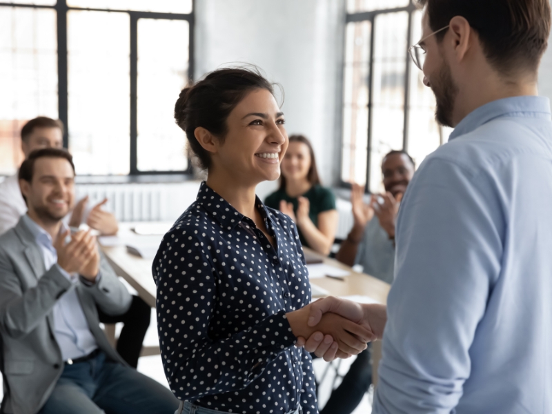 Woman being congratulated at work for a salary increase