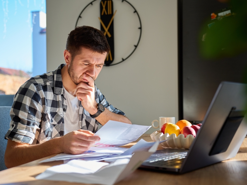 Man reviewing financial documents at home