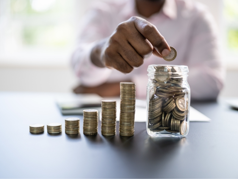 Person consolidating coins into a jar representing old pension pots