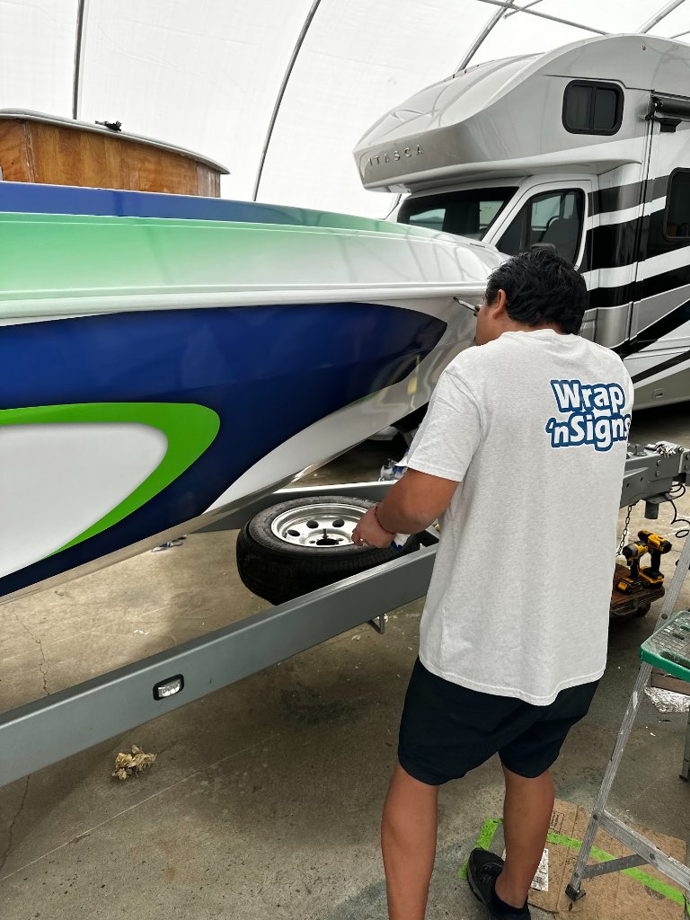 Installer applying a colorful custom boat wrap