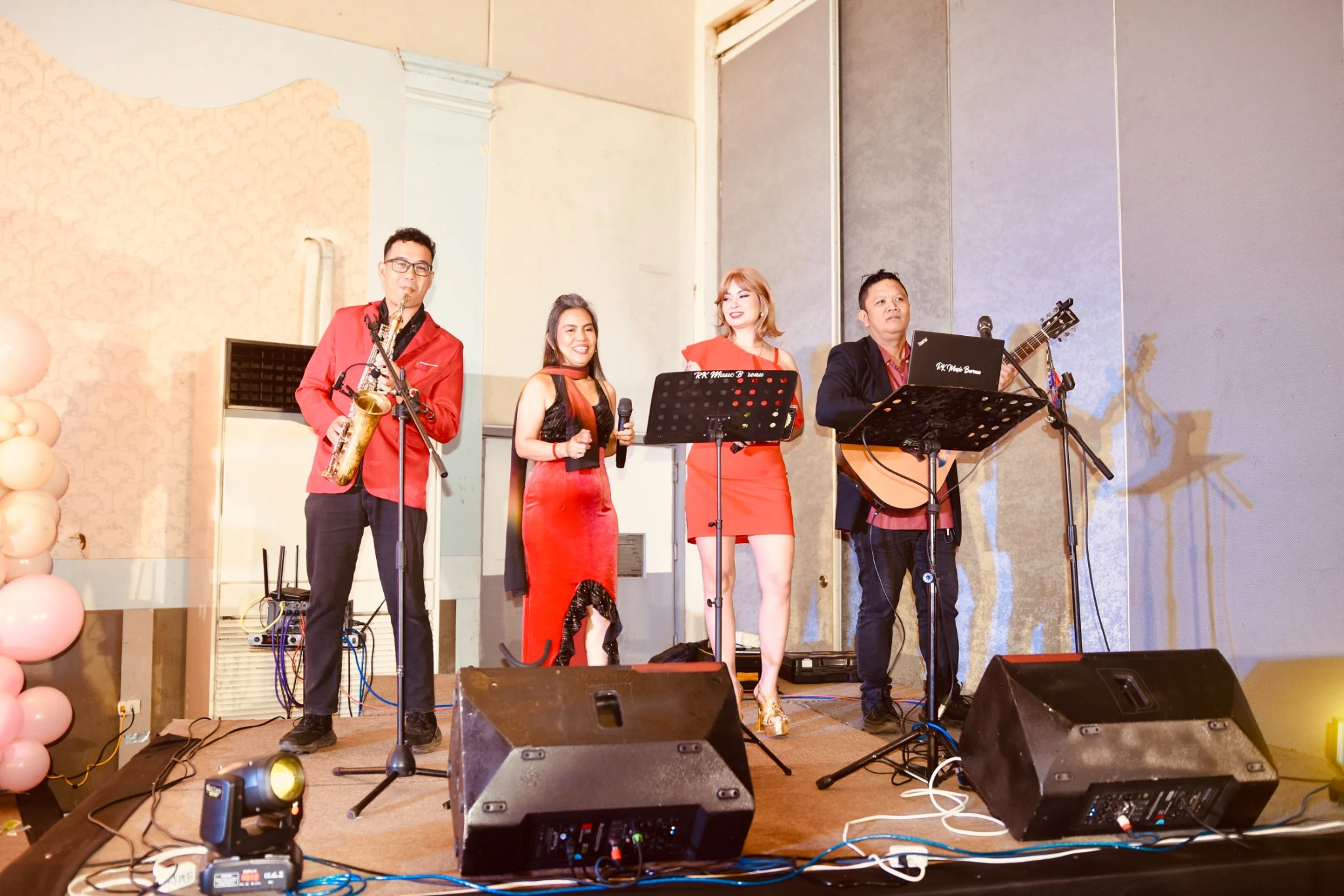 The live band performs among microphones and music stands.