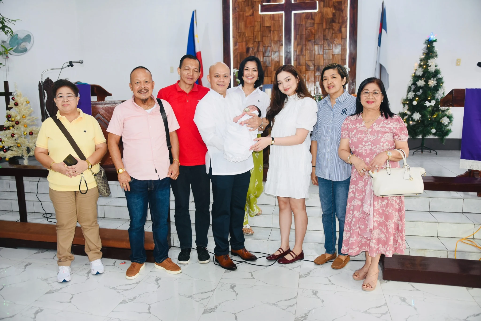 A group poses with the baby in front of the church altar after the ceremony.