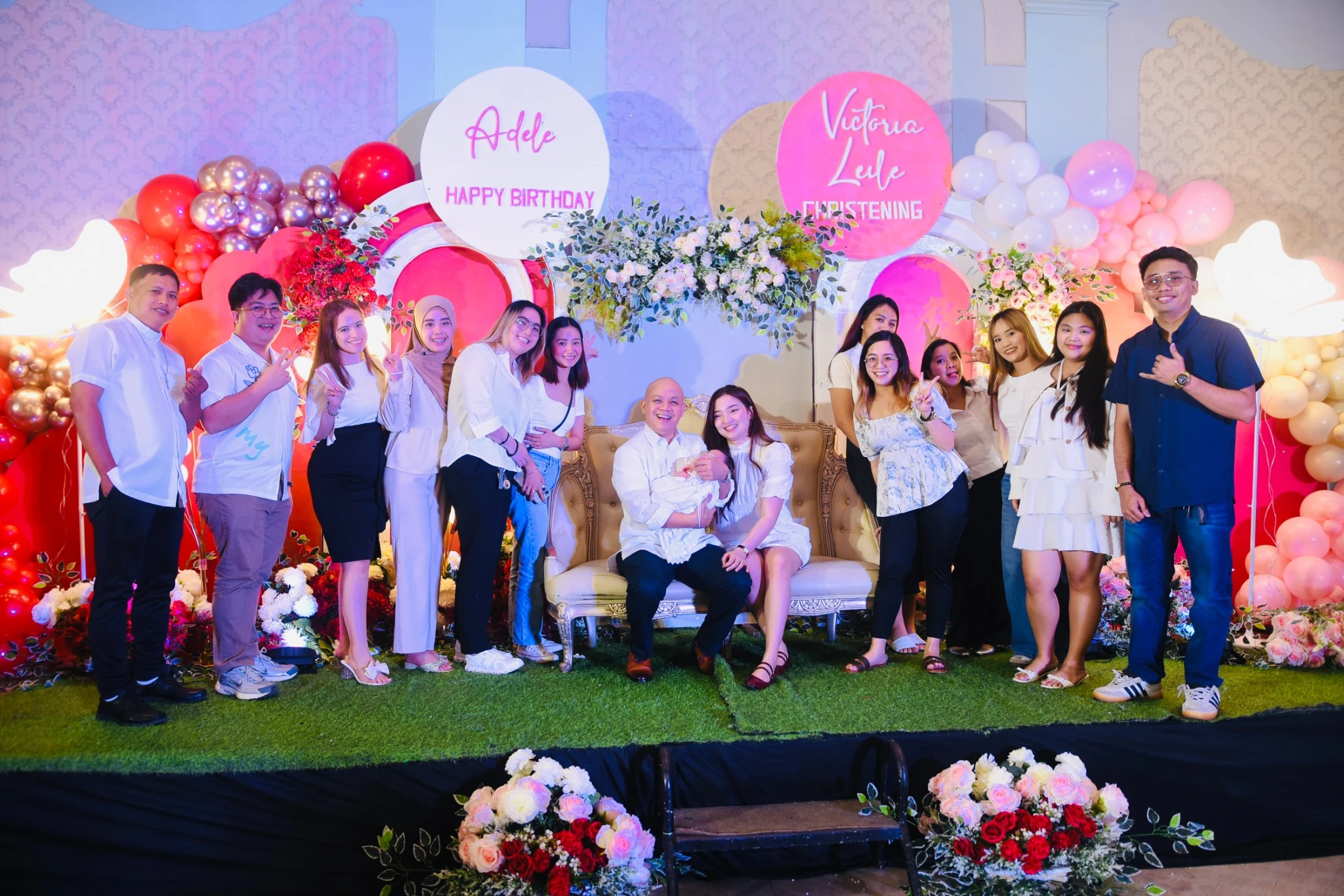 A joyful group portrait on the stage, with several guests making playful gestures.