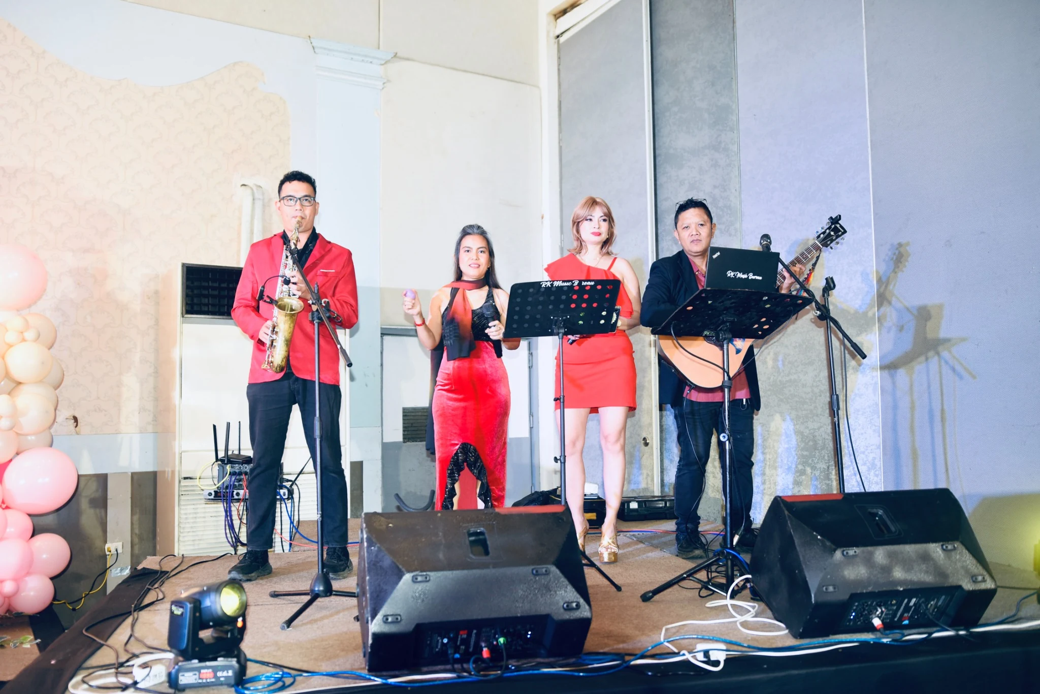 A saxophonist, vocalists, and guitarist perform on the reception stage.