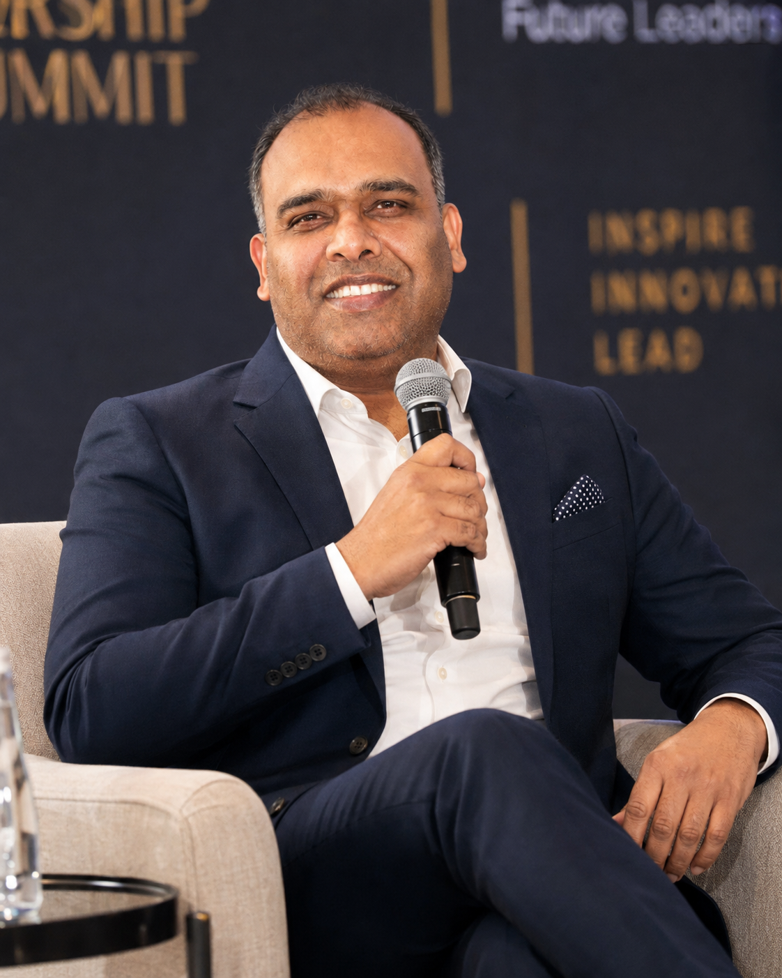 Ashish Goyal speaking on stage at a leadership summit
