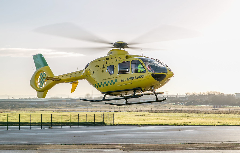 Air ambulance helicopter lifting off from an airfield