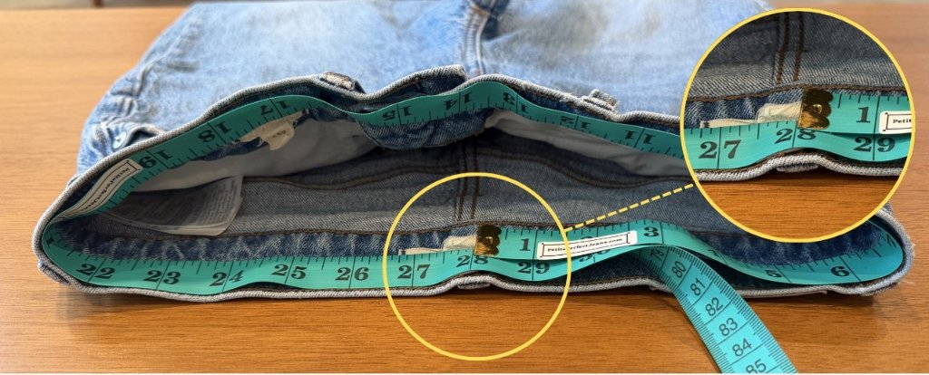 Measuring the waist of a pair of jeans with a flexible tape measure