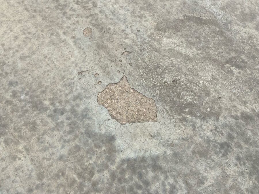 Superfície de concreto com delaminação em estágio avançado: desplacamento da camada superficial, exposição do agregado e deterioração progressiva do substrato. Caso documentado pela equipe técnica da BSB.
