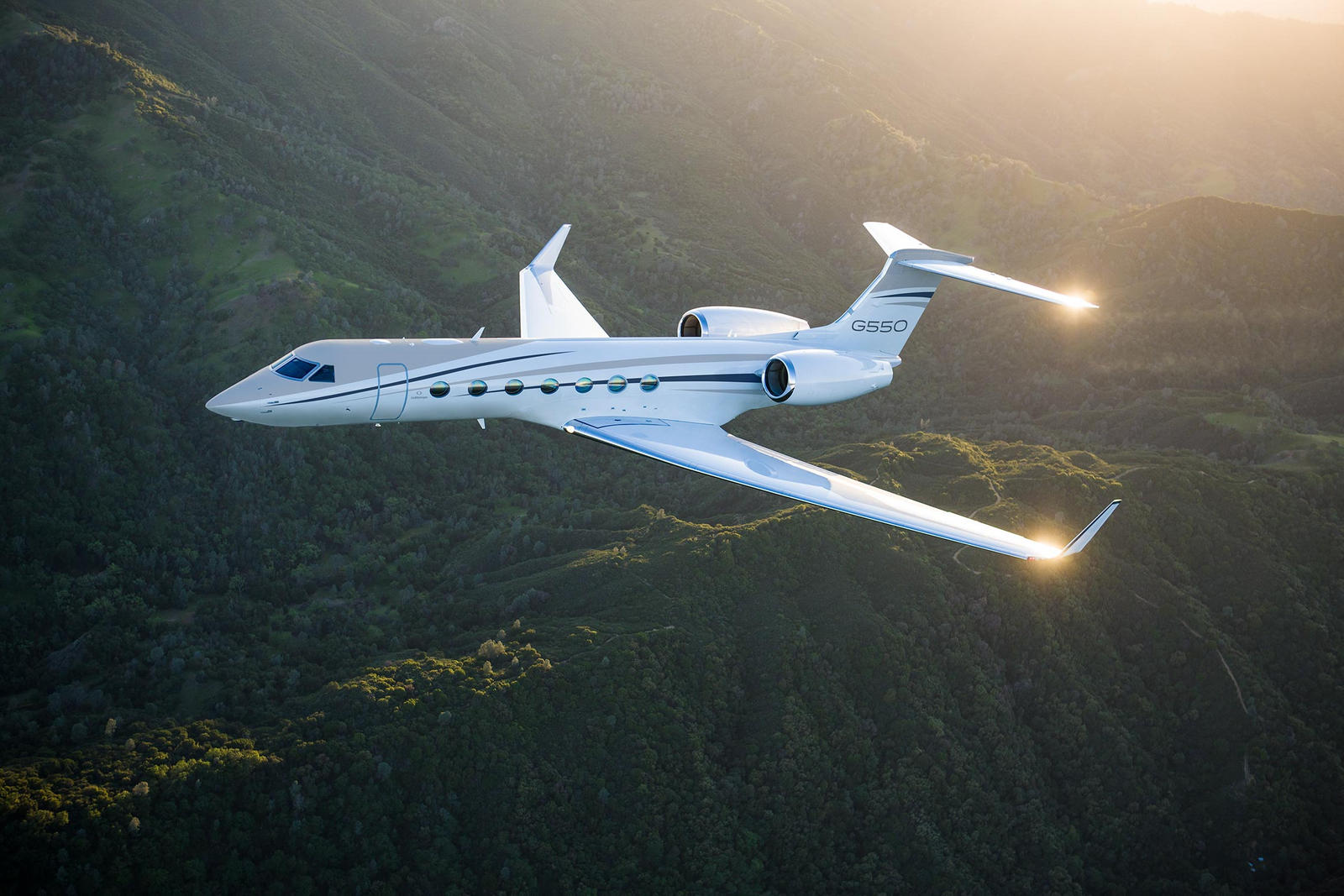 Gulfstream G550 in flight over hills