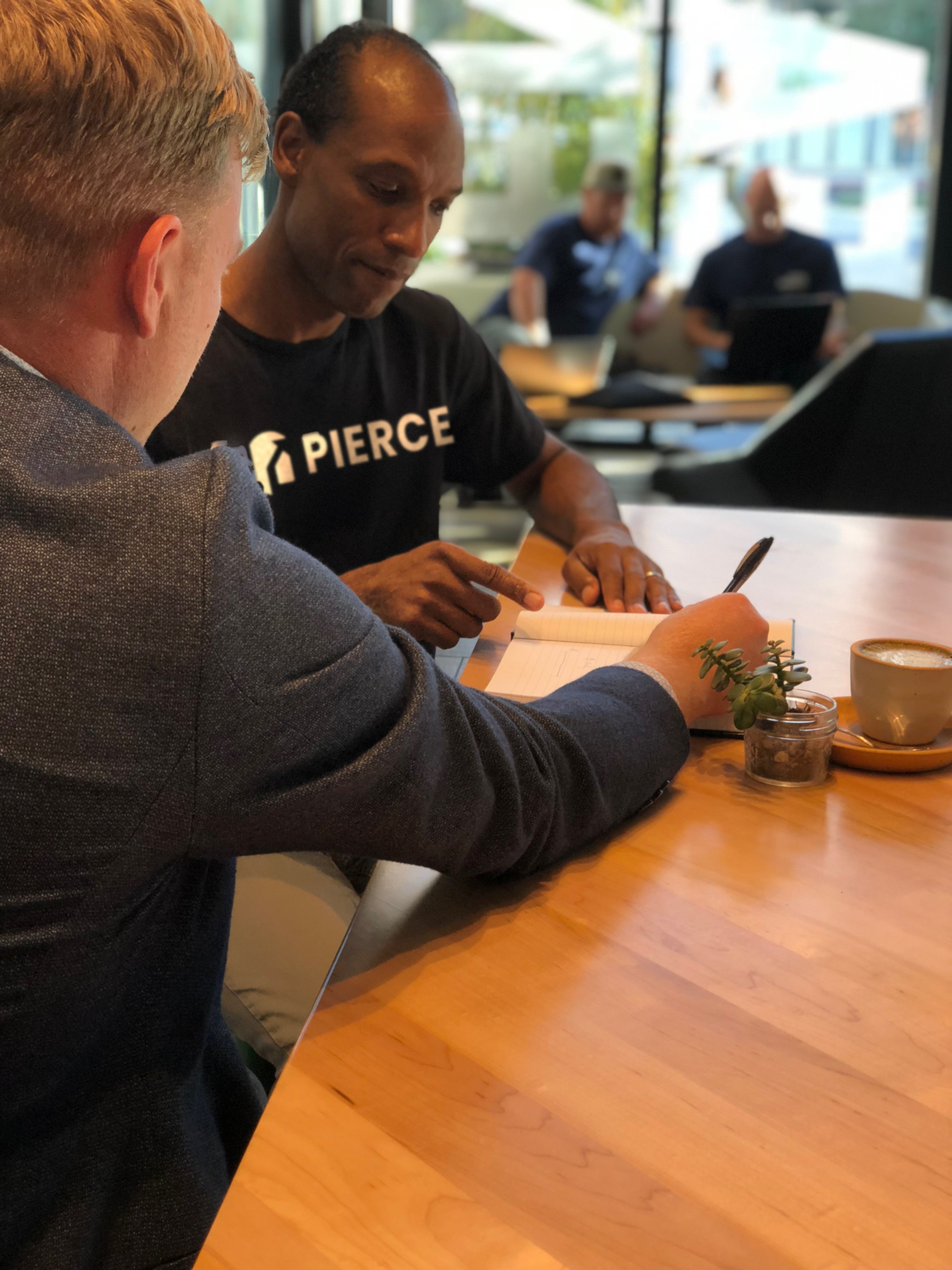 A mentor and a job seeker reviewing notes together at a table