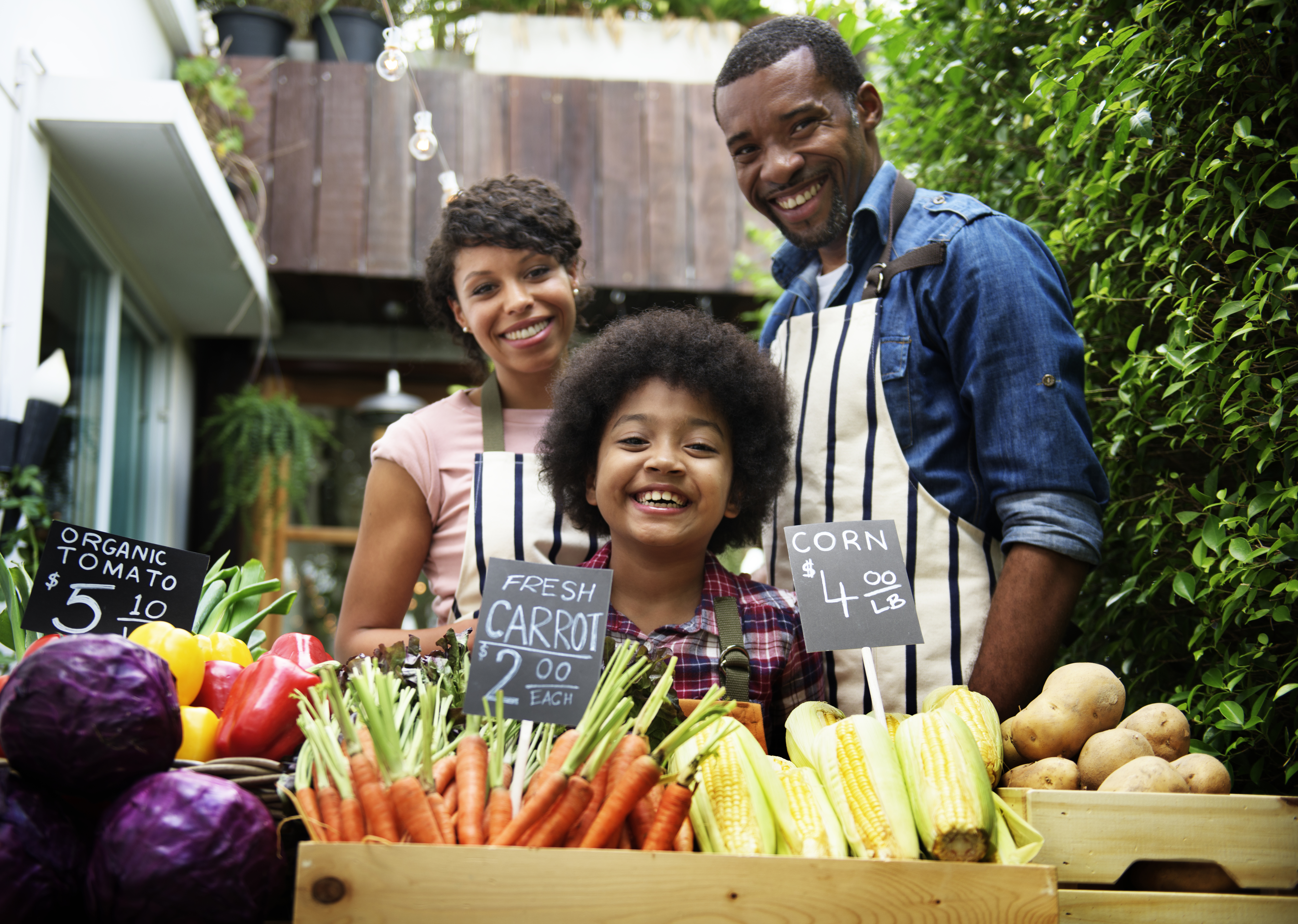 A family running a produce stall at a farmers market