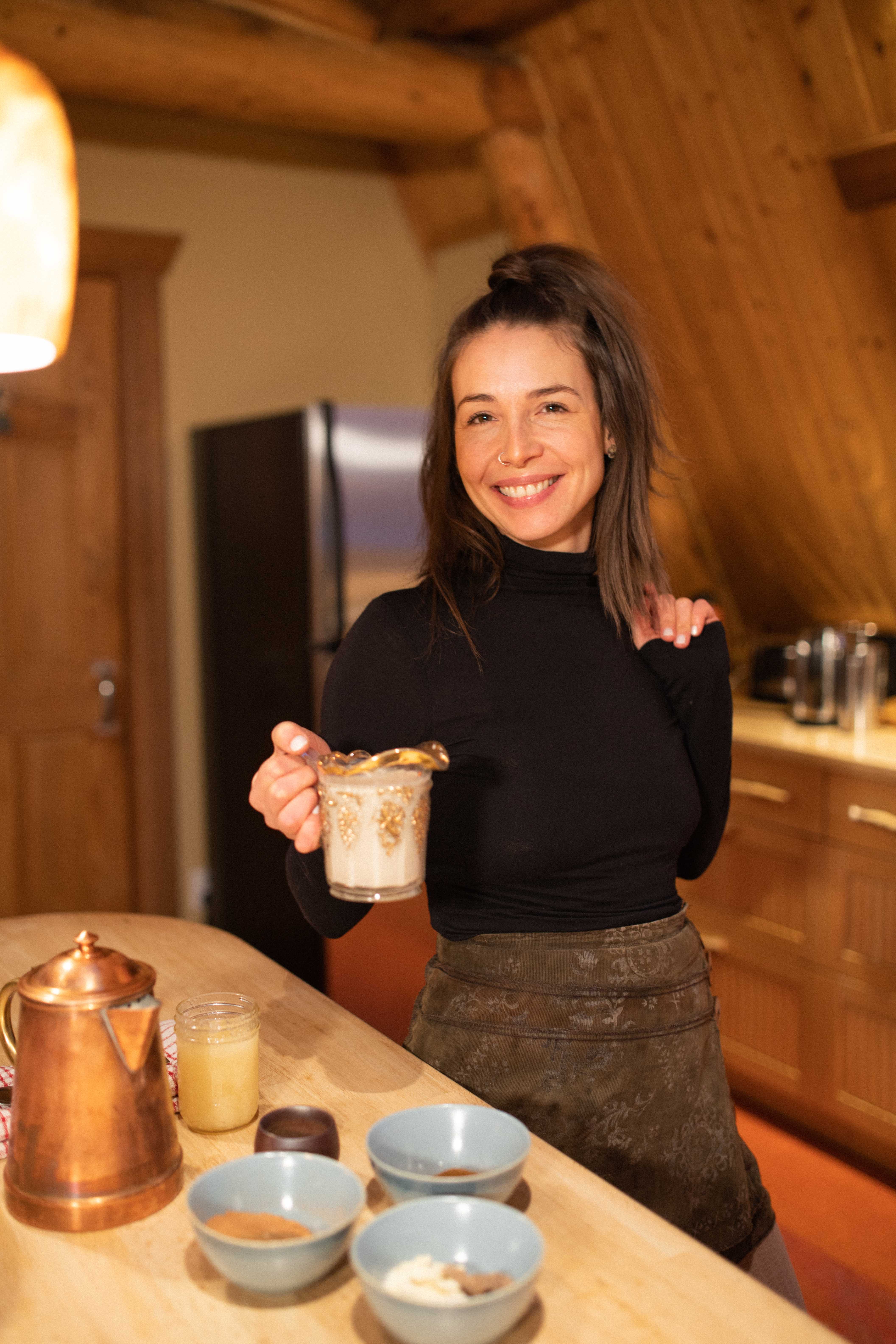 Chef holding a pitcher of cream in a timber kitchen