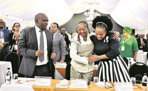 Conference participants greeting one another warmly at a conference table