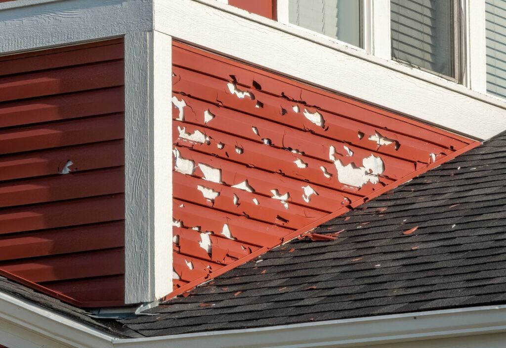 Wind-blown and cracked vinyl siding panels after storm
