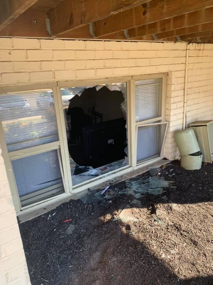 Residential window with severe storm damage requiring emergency repair