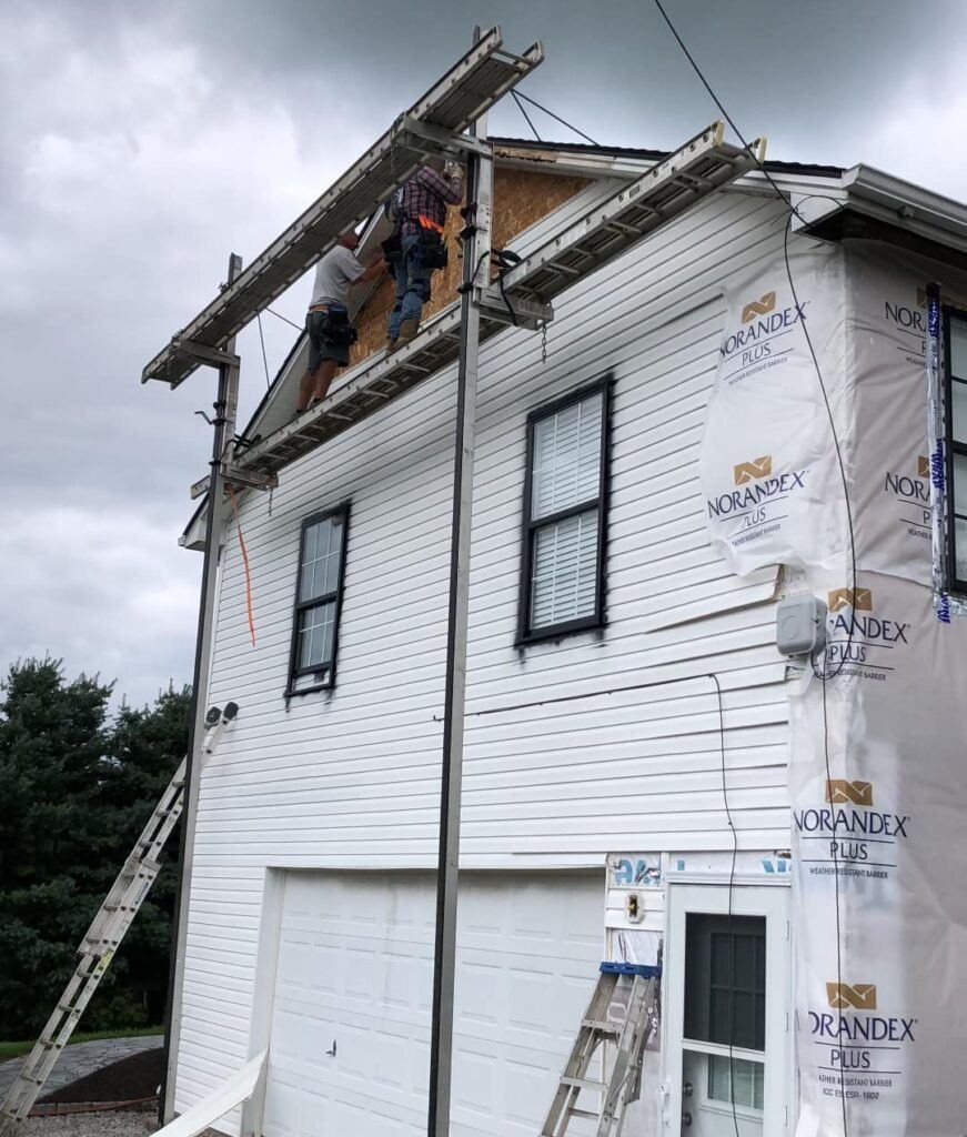 Crew working on siding repair in progress