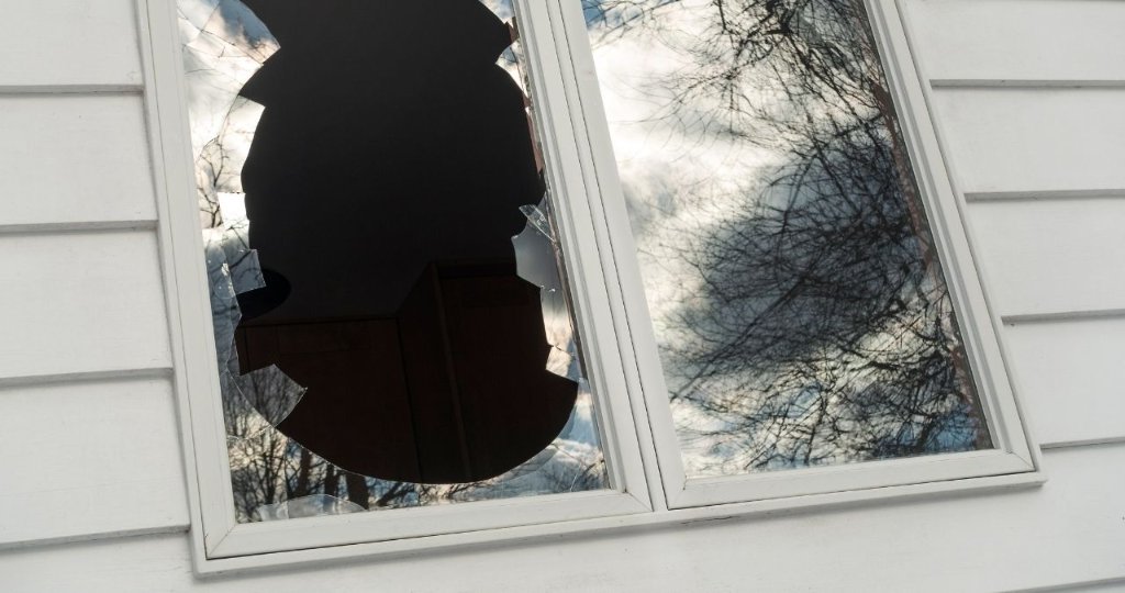 Broken window with shattered glass from storm impact