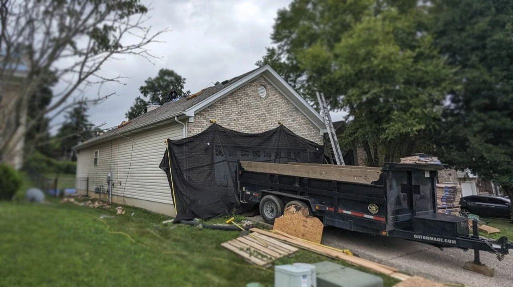 Roofing crew with dump trailer on site