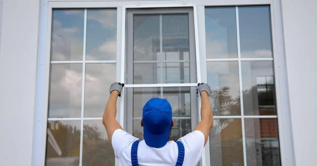 Window installation technician fitting new window screen