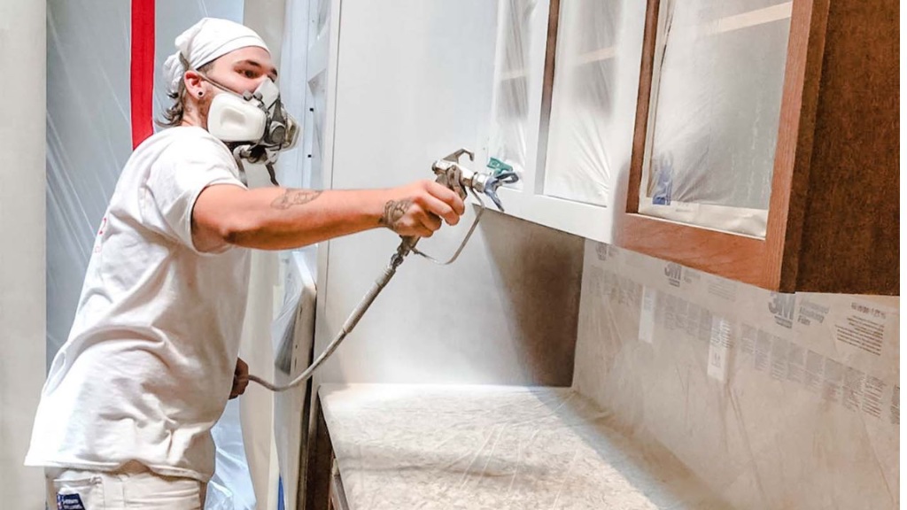 Painter spraying cabinet doors