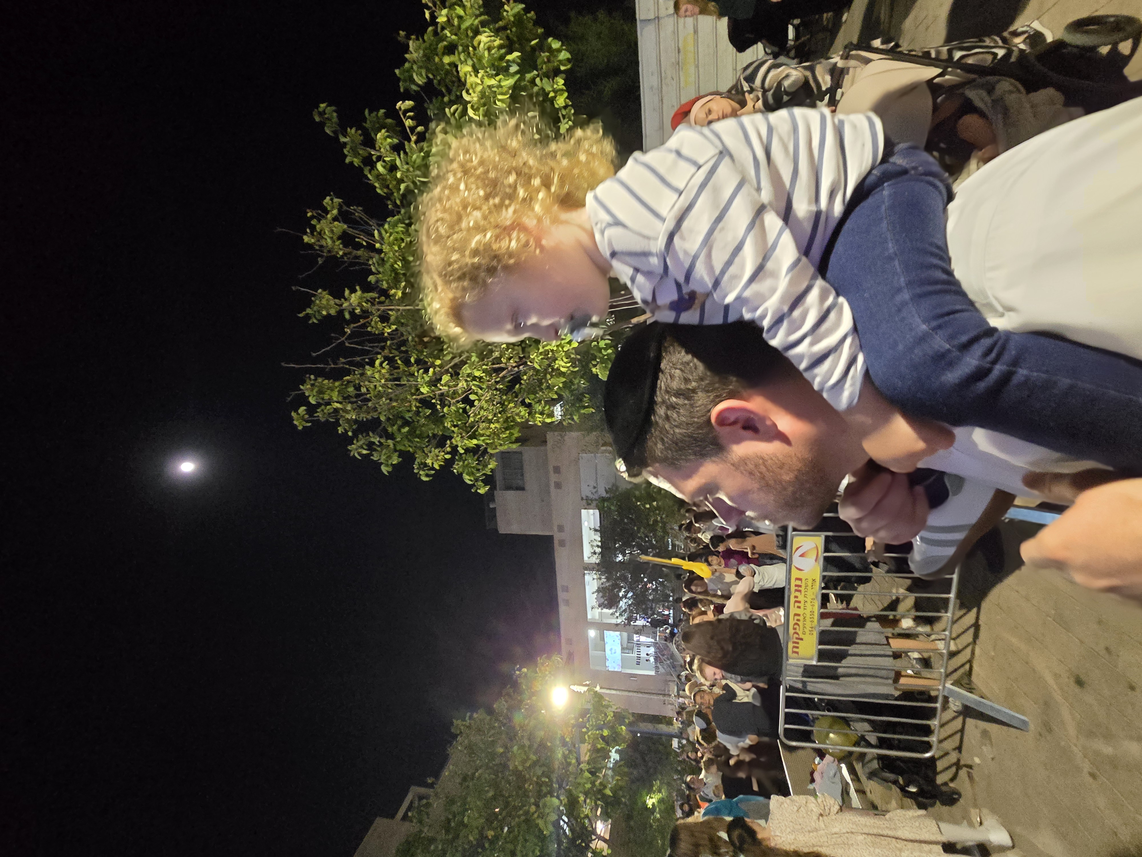 On his shoulders under a Jerusalem moon — the grown-ups came to feel a night, and he came to see it over everyone's head.