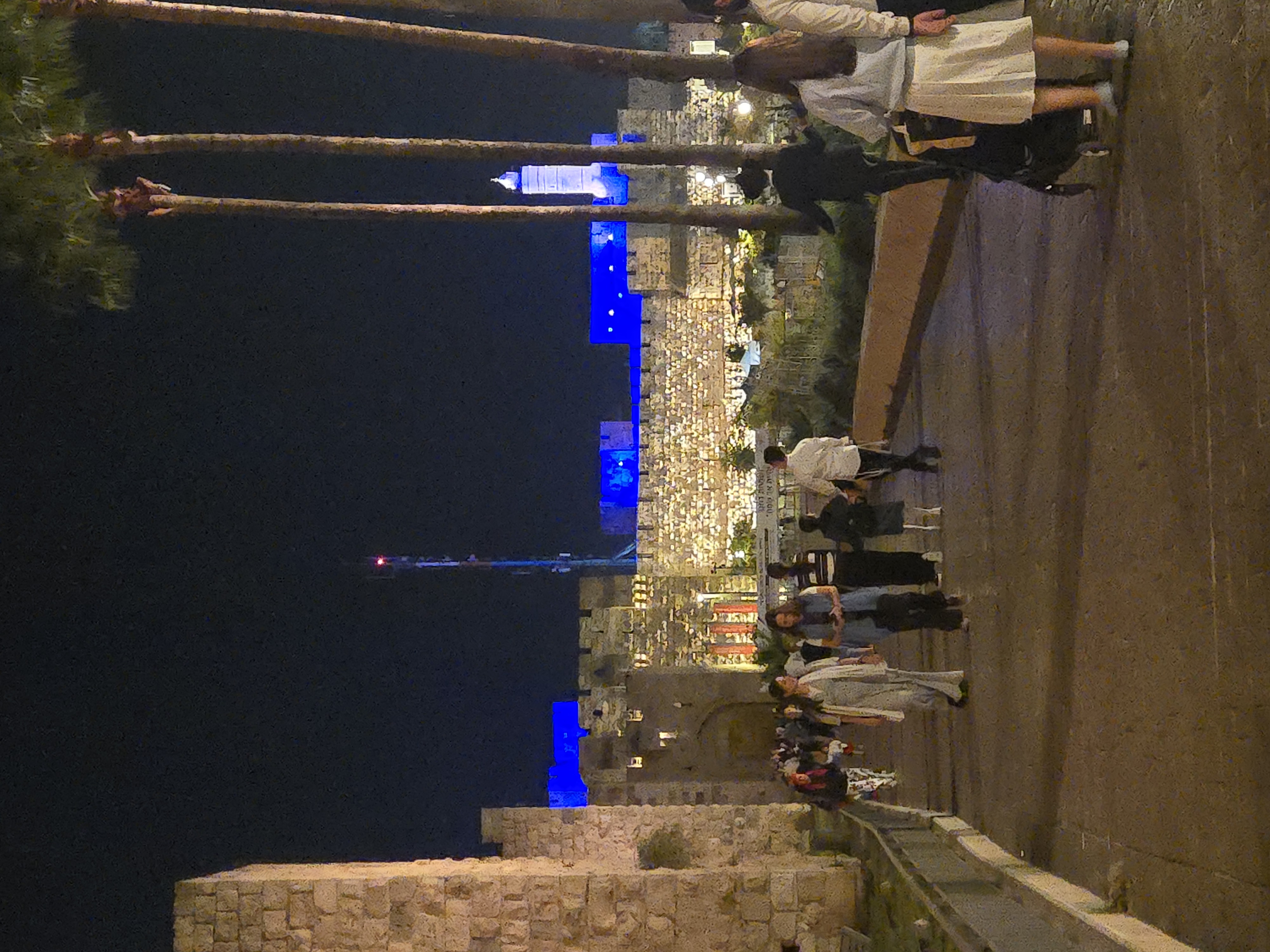 The old walls wear light like festival clothing, and the people walking home past them barely look up. That is the whole miracle — it became ordinary.
