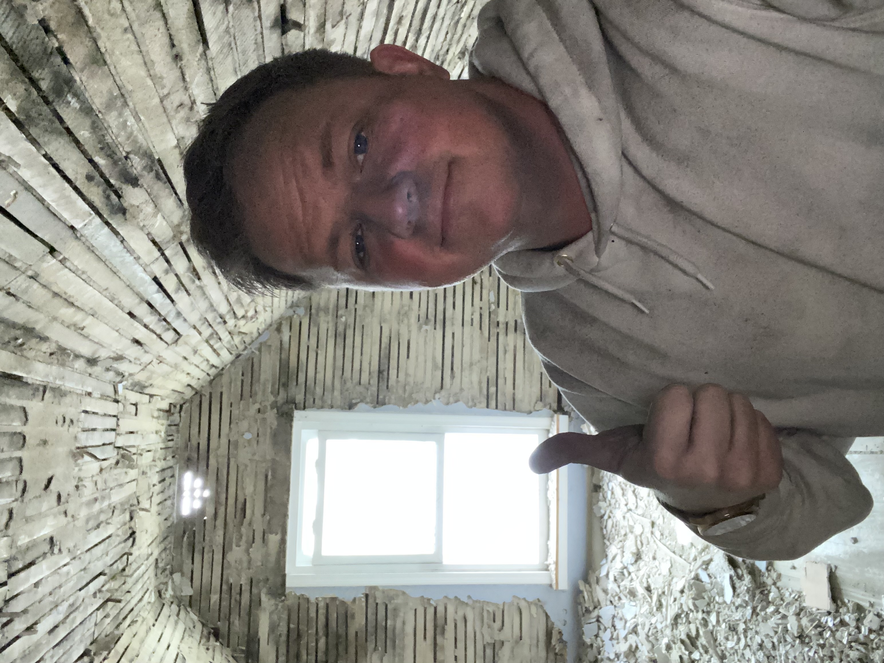 Austin Coon giving a thumbs-up inside an active renovation project in Indianapolis