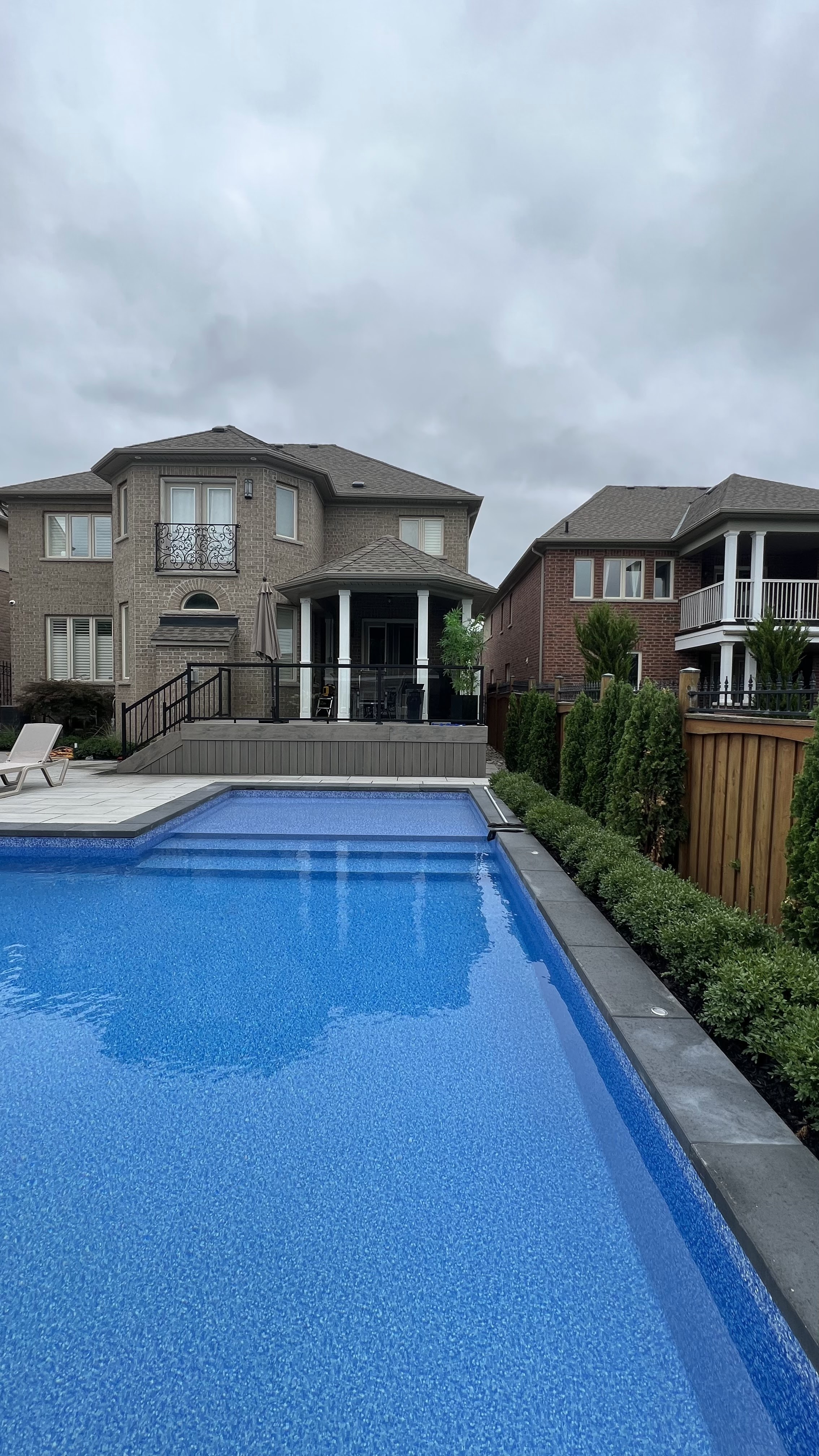 Backyard with composite pool deck, covered gazebo and stone patio built by Fenus Construction