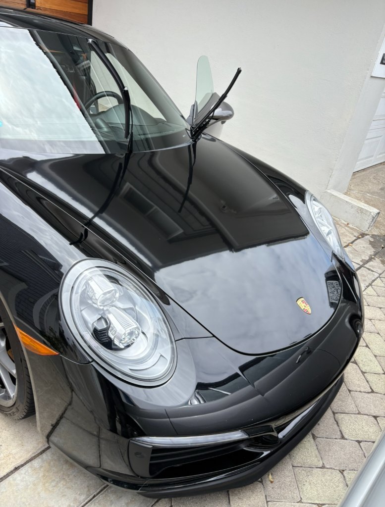Glossy, contaminant-free black Porsche paint after an exterior contact detail by Polish Theory mobile detailing