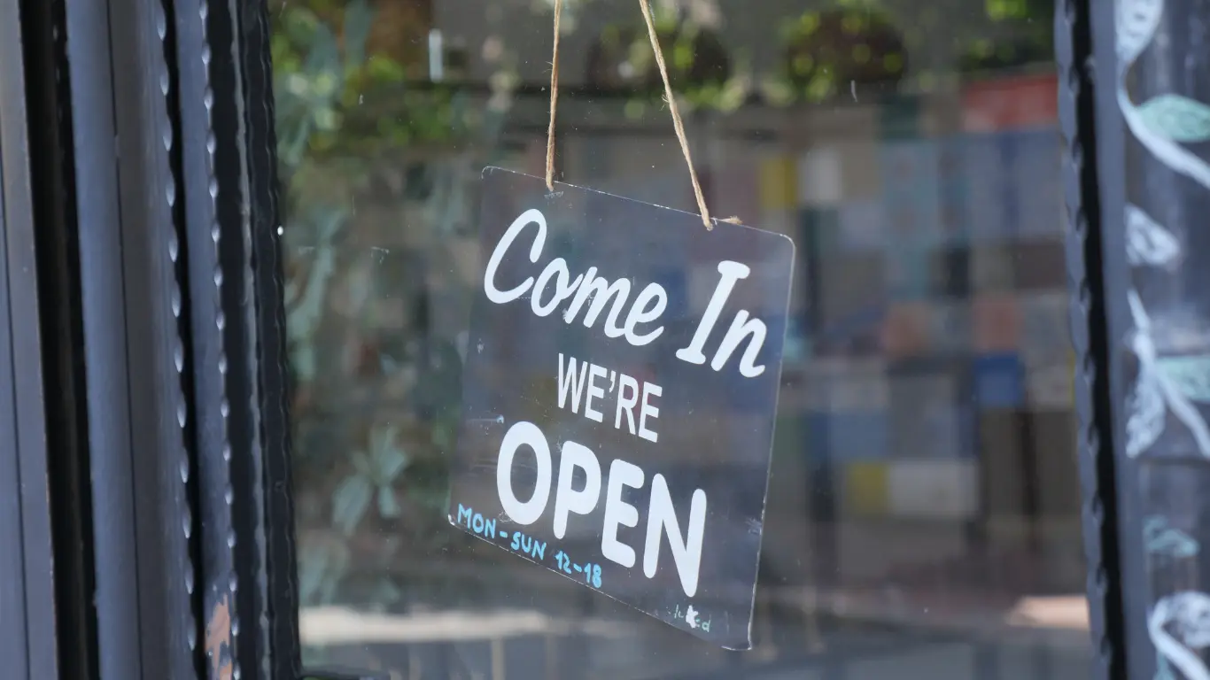 Local business open sign hanging in a shop window