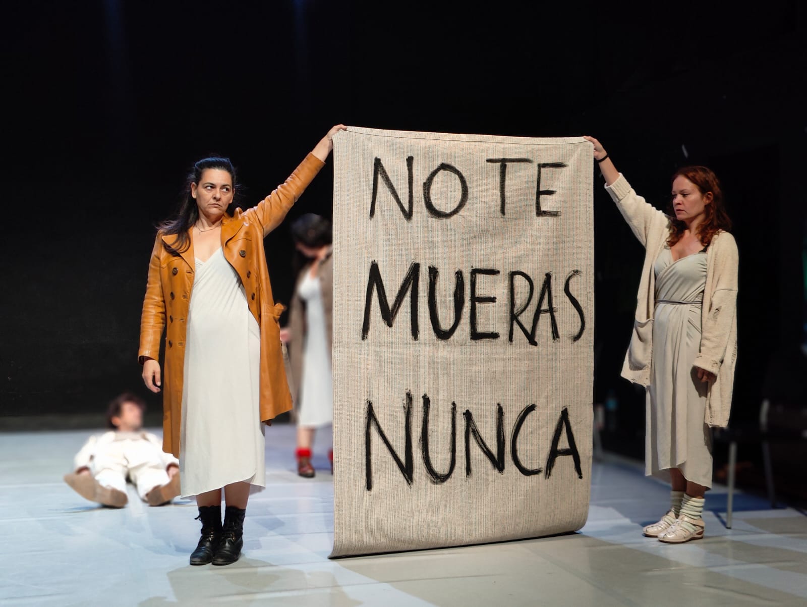 07 · Dos intérpretes sosteniendo el cartel «No te mueras nunca»
