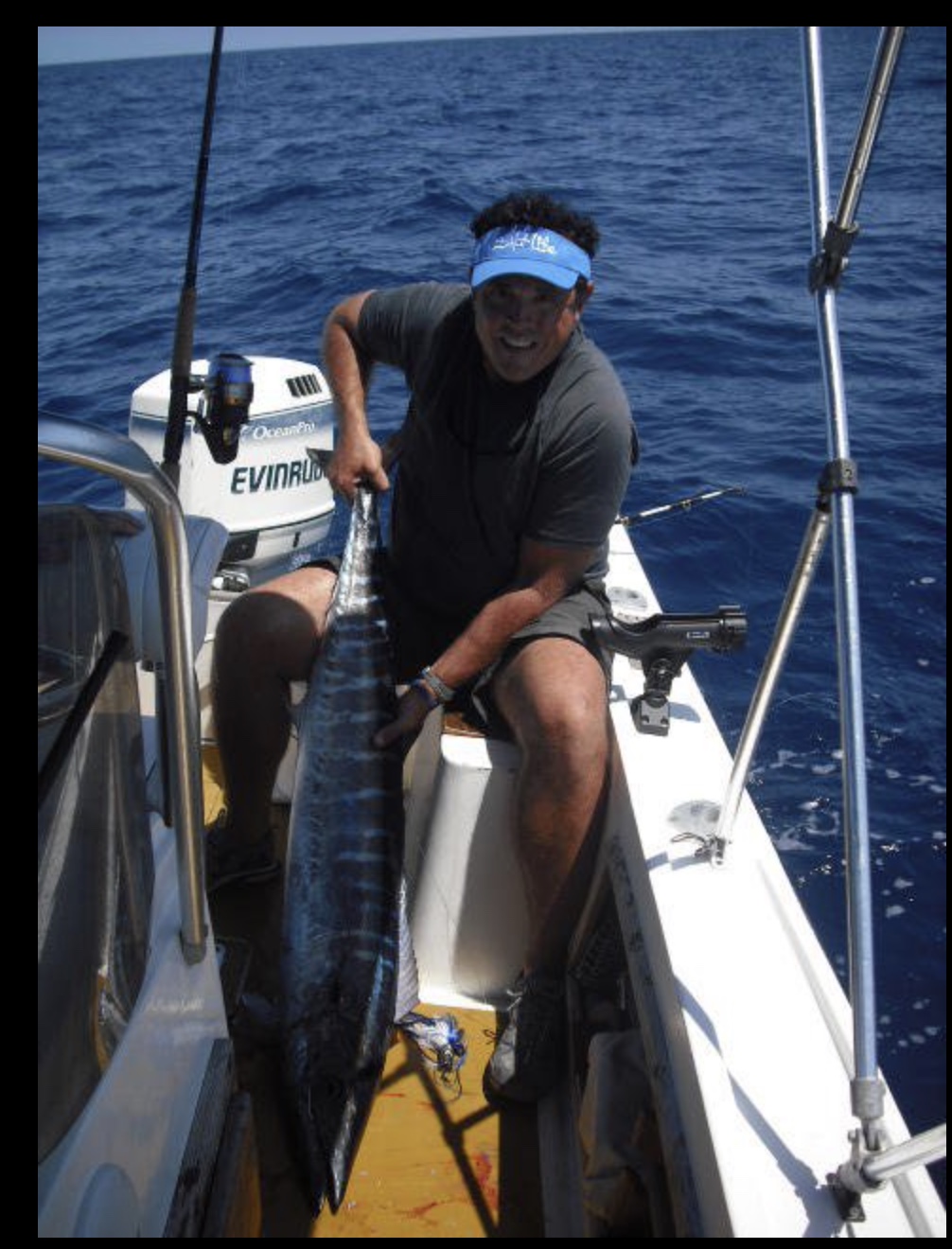 Capt. Ryan with a wahoo on the classic 21-foot Mako, wearing his favorite Salt Life hat