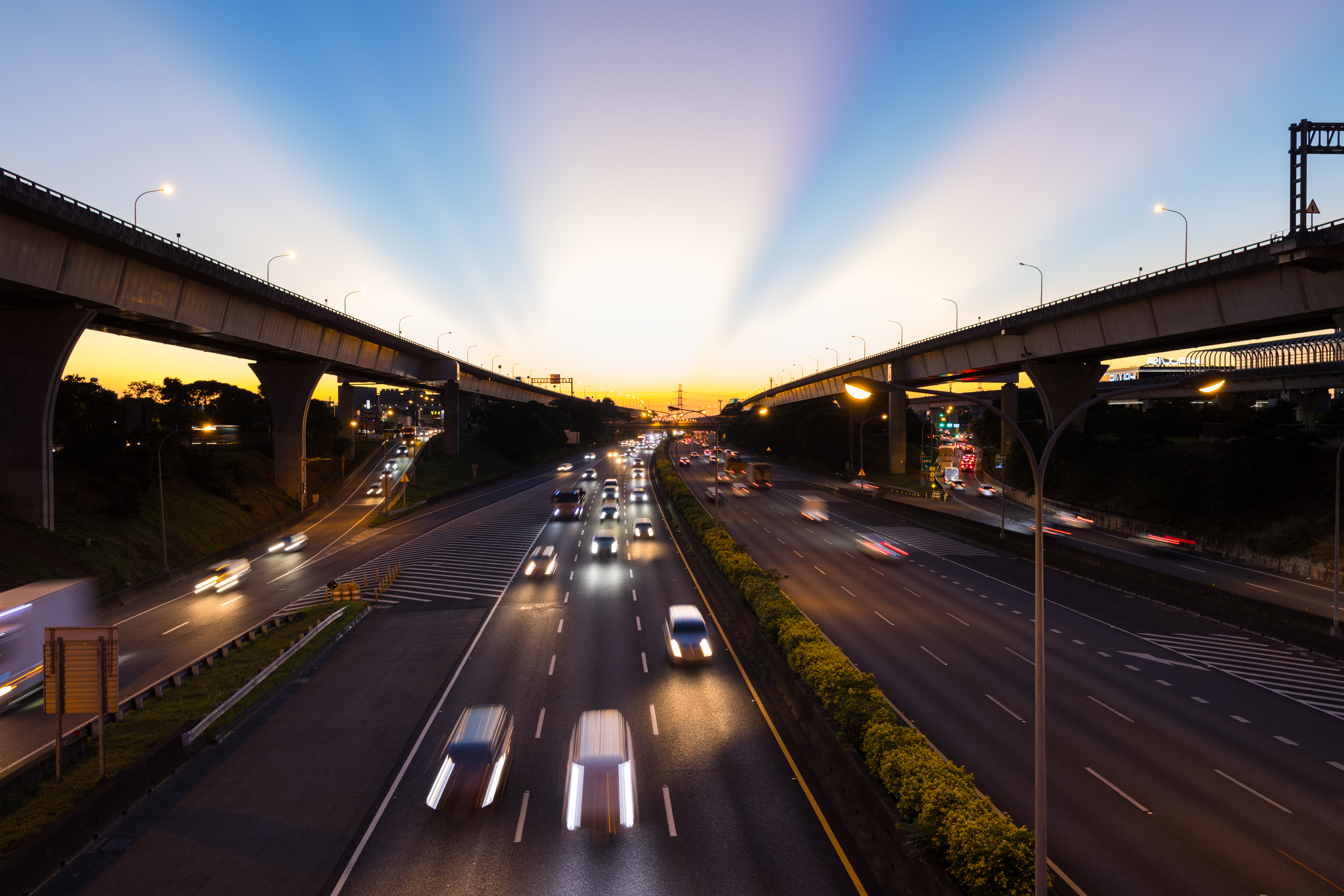City traffic moving along a highway at sunset.