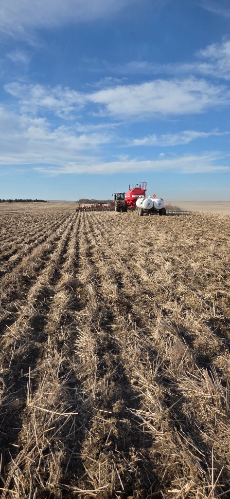 Red tractor with air seeder in field