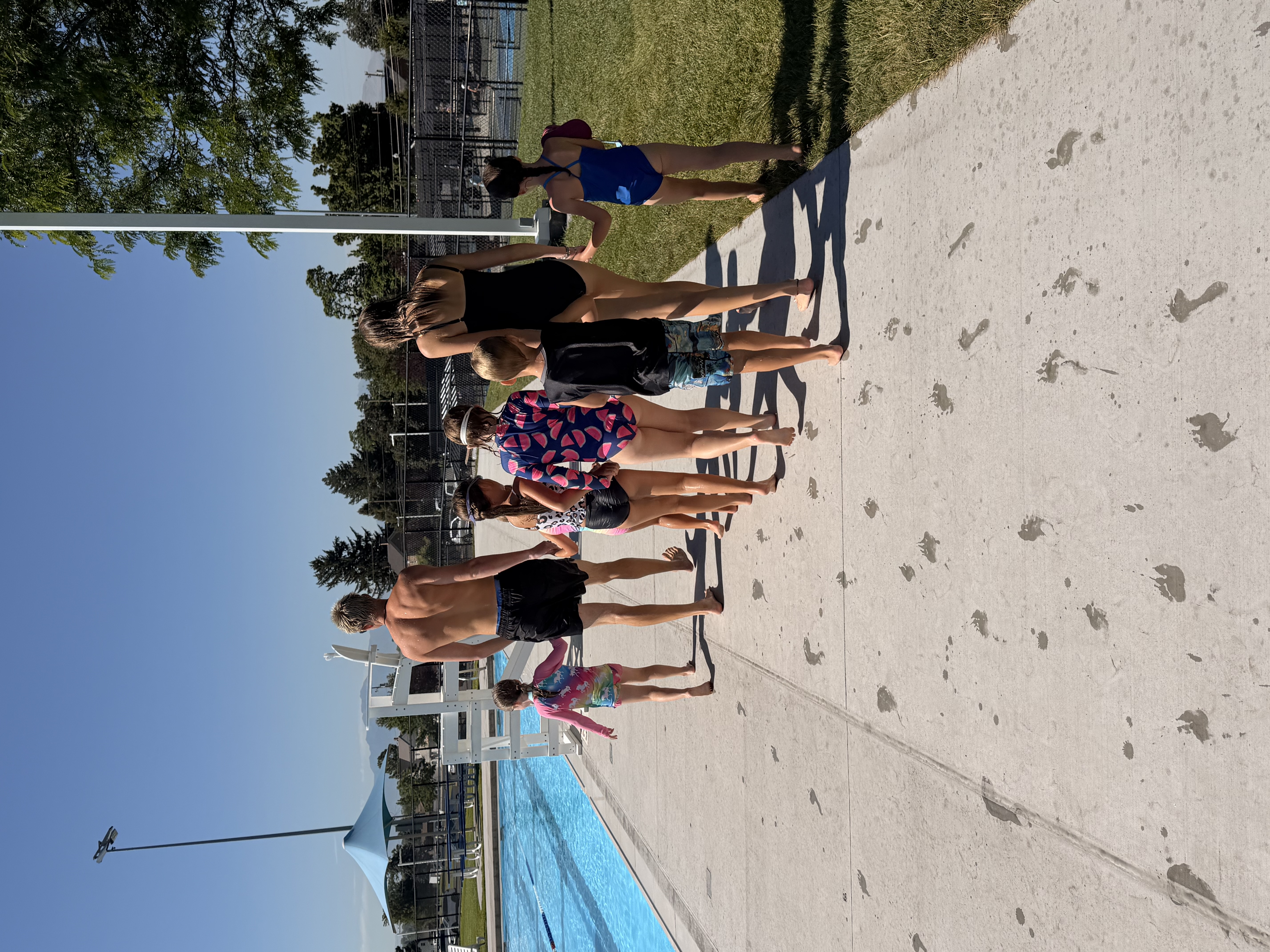Swimmers walking in a line along the pool deck